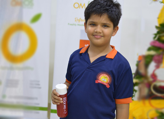 A kid with OMJOOS bottle in hand